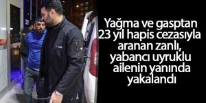 Yağma ve gasptan 23 yıl hapis cezasıyla aranan zanlı, yabancı uyruklu ailenin yanında yakalandı